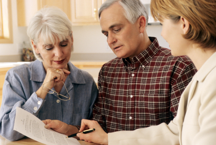 Mature couple talking to financial planner at home